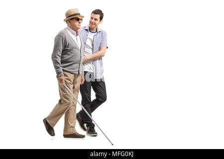 Profil de pleine longueur tourné un blind man walking avec l'aide d'un jeune homme isolé sur fond blanc Banque D'Images