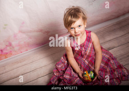 Studio shot of a happy little girl en robe rose. Banque D'Images