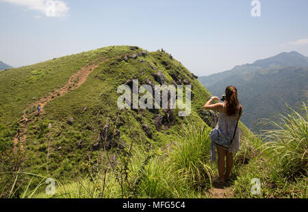 Woman taking photograph of Little Adam's Peak, Ella, le district de Badulla, Province d'Uva, au Sri Lanka, en Asie. Banque D'Images