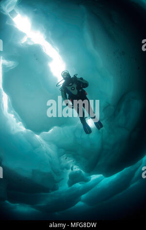 Scuba Diver sous et entre les formations de glace, le lac Sassolo, Sambuco valley, Tessin, Suisse Banque D'Images