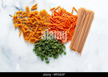 Différents types de pâte sans gluten à partir de pois chiches, lentilles rouges, algues et céréales sains sur une table de marbre blanc. en plongée des arrière-plan de l'alimentation. Banque D'Images