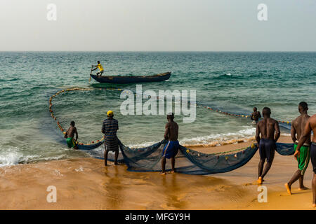 Les pêcheurs locaux tirant leurs filets sur une plage à Robertsport, au Libéria, en Afrique de l'Ouest, l'Afrique Banque D'Images