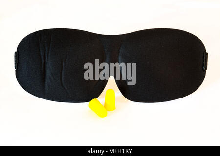 Masque de sommeil noir avec des bouchons d'oreille jaune isolé sur fond blanc. Studio shot. Banque D'Images