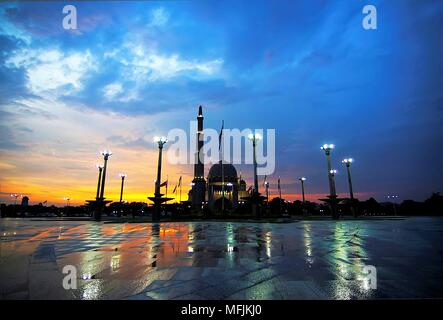 Coucher du soleil glorieux de Putra Mosque, la principale mosquée de Putrajaya, Malaisie, prise après une averse. Vu ici reflète du granit humide de Putra Banque D'Images