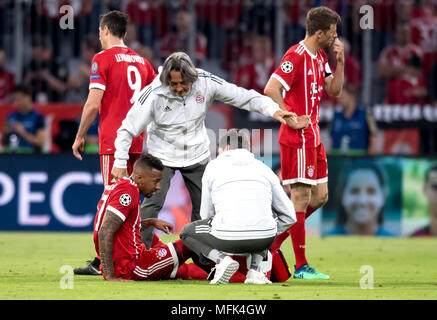 25 avril 2018, Allemagne, Munich : Football, Ligue des Champions, tour de coup, demi-finale, premier leg, Bayern Munich vs Real Madrid. Jérôme Boateng blessés Munich se trouve sur le terrain alors qu'il est traité par l'équipe médecin Hans-Wilhelm Müller-Wohlfahrt (c) et d'autres collaborateurs. Photo : Sven Hoppe/dpa Banque D'Images