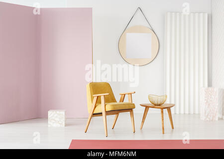 Grand miroir rond avec cadre en bois accroché sur un mur blanc d'un salon intérieur minimaliste avec un mobilier élégant et d'exposition en cubes Banque D'Images