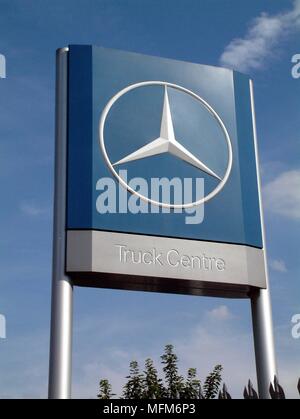 Une grande partie de la route bleu logo Mercedes Benz signe concessionnaire tourné contre un ciel bleu clair. La compagnie se spécialise dans les ventes de camions. Bandphoto / COMPU Banque D'Images