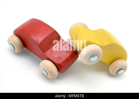 Deux petites voitures jouets en bois rouge et jaune, ont eu un accident frontal. Illustration d'un accident de la circulation. Bandphoto / crédit obligatoire : Hotshoe/Photosh Banque D'Images