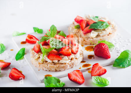 Collation santé, avec du pain, de fraises fraîches, fromage crème douce, menthe, vinaigre balsamique. Petit-déjeuner facile gros plan sur un fond blanc avec l'exemplaire Banque D'Images