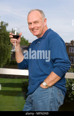 Portrait of a senior man holding a glass of wine and smiling Ref : CRB410 10003 149 crédit obligatoire : Gary Moyes/sem - Allemand Banque D'Images