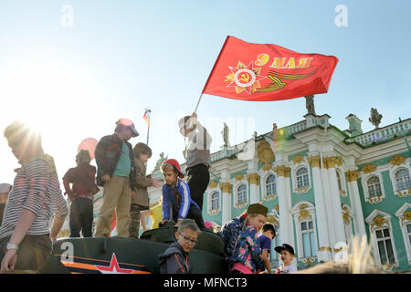 Un homme dans un casque du tankman tient un drapeau sur un véhicule de combat, les enfants sont à proximité, la Place Dvortsovaya, Russie Banque D'Images