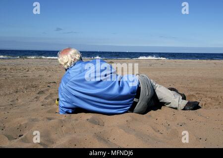 Senior ayant une sieste sur la plage de Portobello, Édimbourg, Écosse. UK. Date : 16.01.2006 Ref : B343 093051  0002 COMPU Banque D'Images