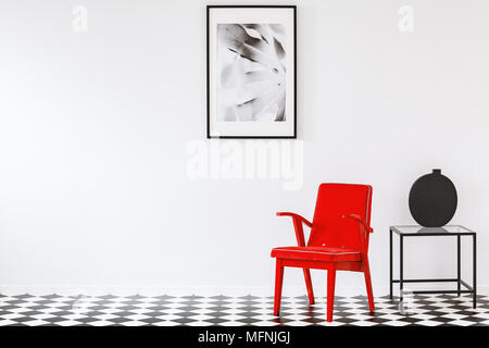 Fauteuil rouge vif dans un noir et blanc salon minimaliste de l'intérieur est un amateur d'art Banque D'Images