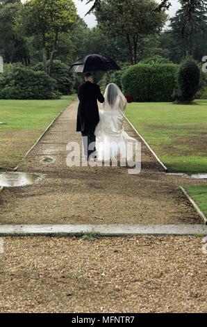 Vue arrière d'une femme et un homme marche sous un parapluie Ref : CRB457  0057 103646 CRÉDIT OBLIGATOIRE : Helen Maynard Sem - Allemand / Banque D'Images