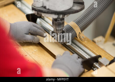 Carpenter avec la perceuse et le conseil à l'atelier Banque D'Images