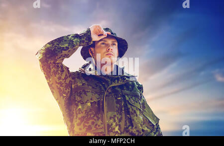 Jeune soldat en uniforme militaire sur sky Banque D'Images