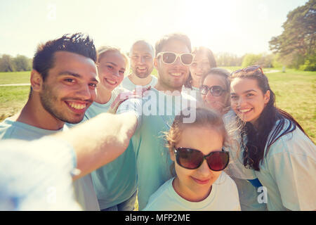 Groupe de volontaires prenant en selfies téléphone intelligent Banque D'Images