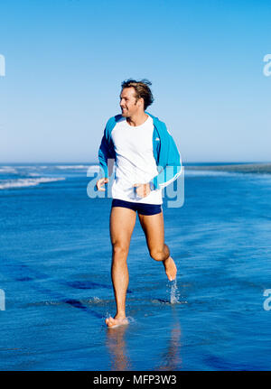 Jeune homme qui court sur la plage Ref : CRB421 10037 002 crédit obligatoire : Sven Arnstein Sem - Allemand / Banque D'Images