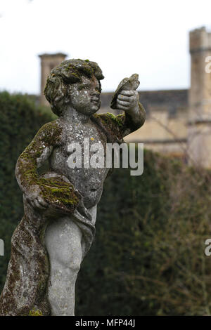 Chérubin tenant un oiseau, dans des jardins au Château de Sudeley, Gloucestershire. Banque D'Images