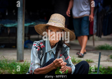 Fuli Village, Yangshuo, Guangxi, Chine - le 2 août 2012 : Portrait d'une vieille femme chinoise la vente de légumes dans un marché de rue au Village de Fuli Banque D'Images