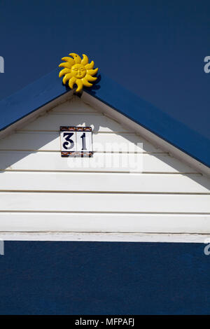 Numéro 31 cabane de plage avec soleil jaune au printemps à Mudeford Hengistbury Head, Christchurch, en Angleterre. Banque D'Images