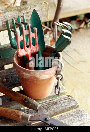 Outils de jardinage y compris la fourche et trowrl terre cuite en pot sur banc, New York, USA Banque D'Images