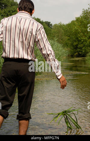 Vue arrière d'un homme jetant l'herbe dans la rivière REF : 10015 026 CRUSC Crédit obligatoire : Stuart Cox/sem - Allemand Banque D'Images
