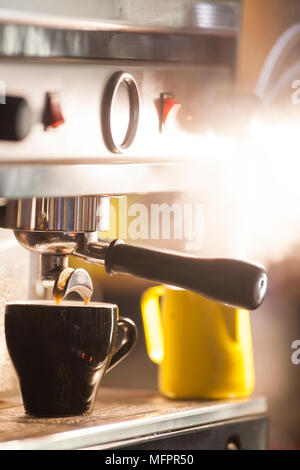 Enlever les tasses de café assis sur le dessus de la machine à expresso Banque D'Images