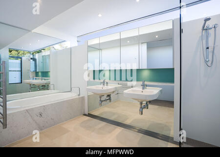 Double lavabo à côté d'une baignoire dans une salle de bains moderne Banque D'Images