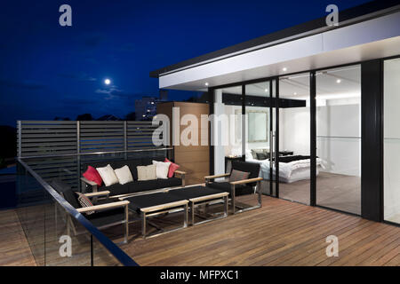 Table et chaises sur la terrasse fleurie sur maison moderne Banque D'Images