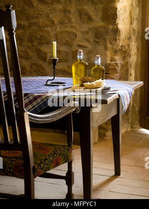 Bouteilles d'huile et de pain sur la table rustique de salle à manger de style campagnard Banque D'Images