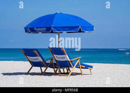 Détendez-vous à Delray Beach en Floride sur le sable, sous un parasol, de chaises longues à la recherche à la mer bleue. Banque D'Images