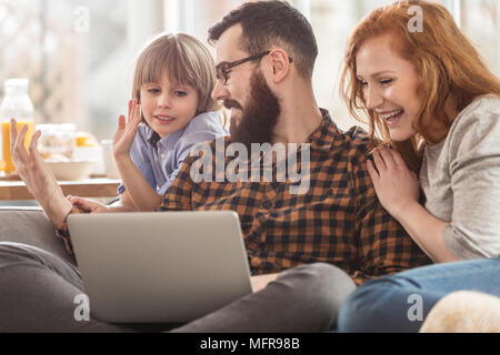 Heureux fils, mère et père de regarder un film sur un ordinateur portable ensemble Banque D'Images