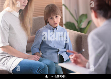 Close-up d'un enfant autiste l'écoute d'un thérapeute au cours de la consultation Banque D'Images