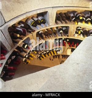 Cave à vin en maison de campagne vue d'au-dessus des étagères courbées en colimaçon gris bouteilles Banque D'Images