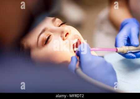 Male dentist le traitement de dents pour jeune femme patient dans un centre. Banque D'Images