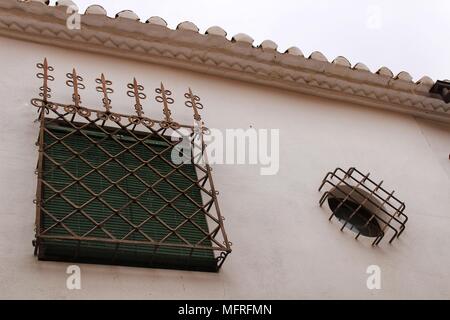 Fenêtre avec détails en fer forgé vert et aveugles sur façade en pierre blanche dans la région de Villanueva de los Infantes, Castille-la Manche, Espagne Banque D'Images