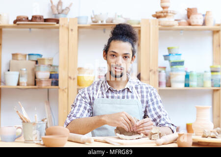 Portrait of young man confiant à modeler pot en atelier et looking at camera Banque D'Images