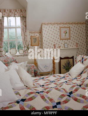 Lit double avec couette patchwork dans une chambre de style campagnard Banque D'Images