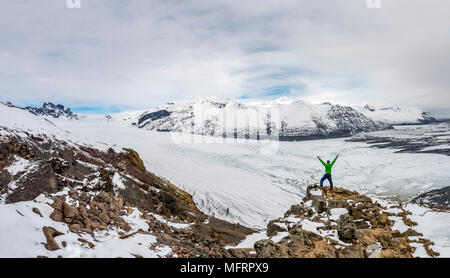 Randonneur étend ses bras vers le haut, vue de langue du glacier, glacier Skaftafellsjökull, le parc national du Vatnajökull, le sud de l'Islande Banque D'Images