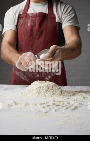 Portrait du chef la préparation de pâte et de briser l'oeuf Banque D'Images