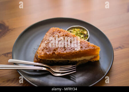 Dessert traditionnel turc Ekmek Kadayifi / Le Pudding sur une surface en bois. Banque D'Images