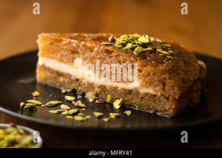 Dessert traditionnel turc Ekmek Kadayifi / Le Pudding sur une surface en bois. Banque D'Images