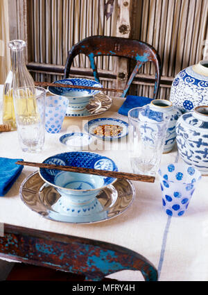 Un détail d'une table à manger couverts vaisselle chinois bleu et blanc carafe verres baguettes ; Banque D'Images