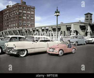 Une petite voiture à côté d'un grand Cadillac sur Wacker Drive, Chicago, Illinois. Le 24 septembre 1955. Libre à partir de colorisée 4x5 pouces B&W négatif. Banque D'Images