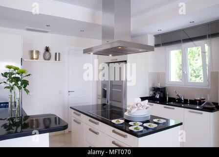 Une hotte au-dessus de l'unité de l'île centrale avec vitro céramique dans cuisine moderne Banque D'Images