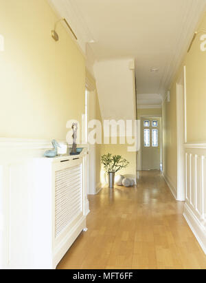 Couloir jaune, moderne avec plancher de bois, couverts, radiateur et porte avant avec des vitraux. Banque D'Images