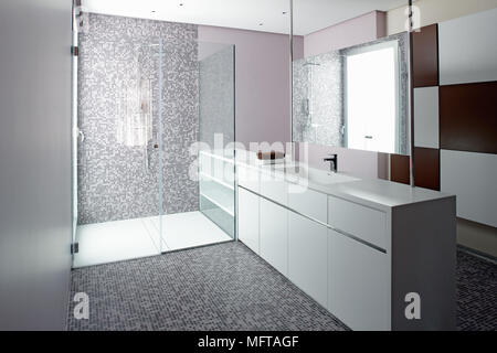 Miroir au-dessus de lavabo situé dans armoire à côté espace douche avec écran de verre porte dans salle de bains contemporaine Banque D'Images