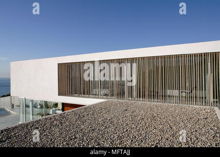 Extérieur de maison moderne sur différents niveaux avec fenêtre ombragée par des perches en bambou Banque D'Images