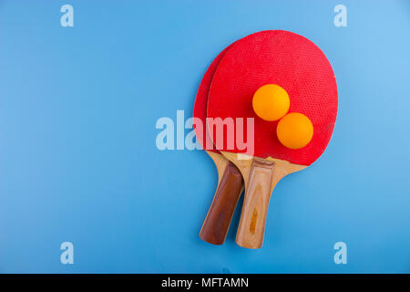 Raquettes et balles de tennis de table sur fond bleu Banque D'Images